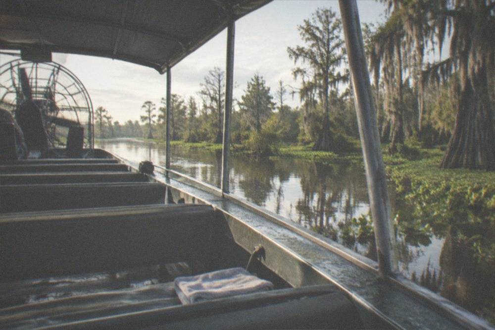 Rows of bench seats inside a large passenger airboat on a swamp tour