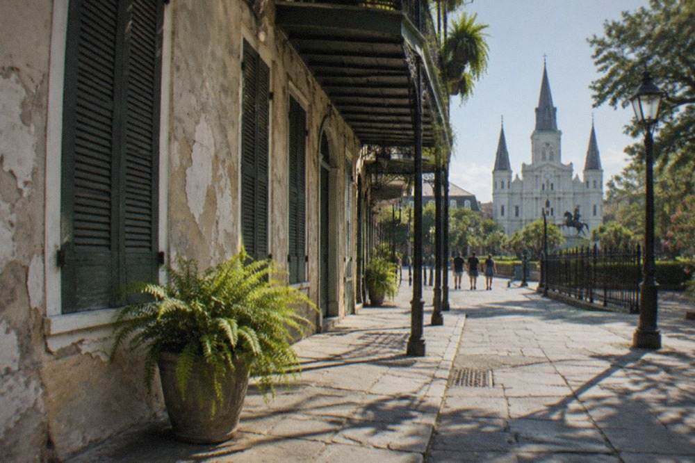 Wrought iron balcony and shuttered windows on a French Quarter building in morning light
