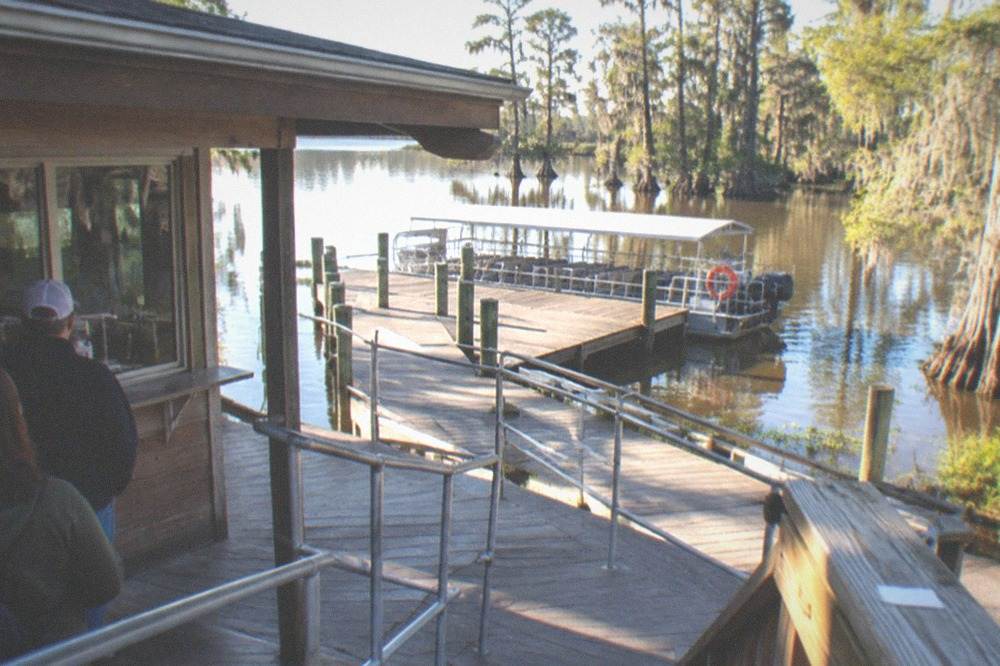 Ticket window and queue railing at a swamp tour departure dock in morning light